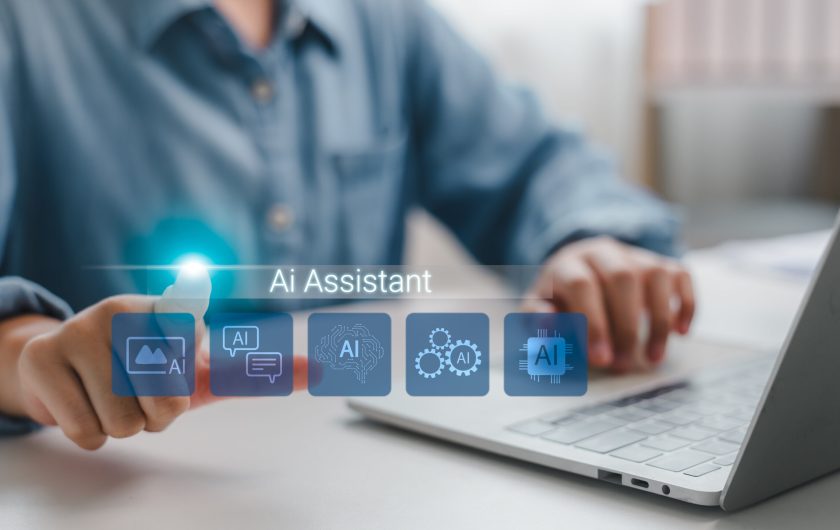 Person using AI assistant interface on laptop with digital icons, concept of artificial intelligence in everyday life, smart technology, and virtual assistant productivity tools. Person using AI assistant interface on laptop with digital icons, concept of artificial intelligence in everyday life, smart technology, and virtual assistant productivity tools.
